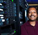 A SLAC employee next to large computers