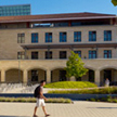 A girl studies at the fountain outside Green Library