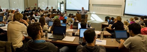 Professor at front of classroom talking with students