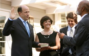 John Roos is sworn in by Judge Thelton Henderson while Roos's wife, Susan, and son David look on.