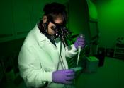 Image - Researcher wears night-vision goggles in darkroom setting.